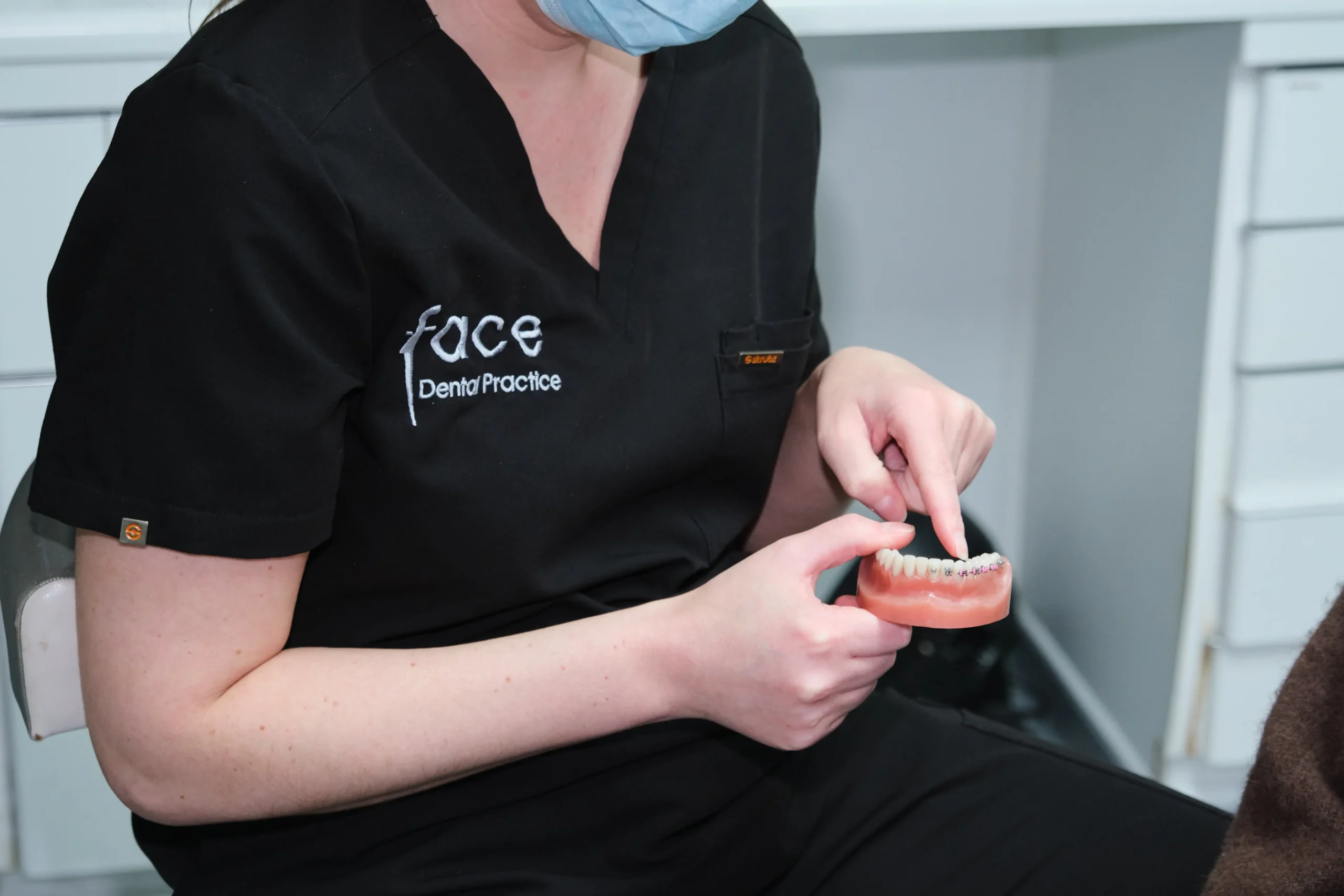 Dentist explaining how fixed braces work at Face Dental